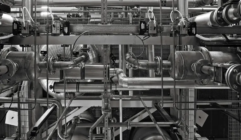 Process pipework and valves running through an industrial plant.