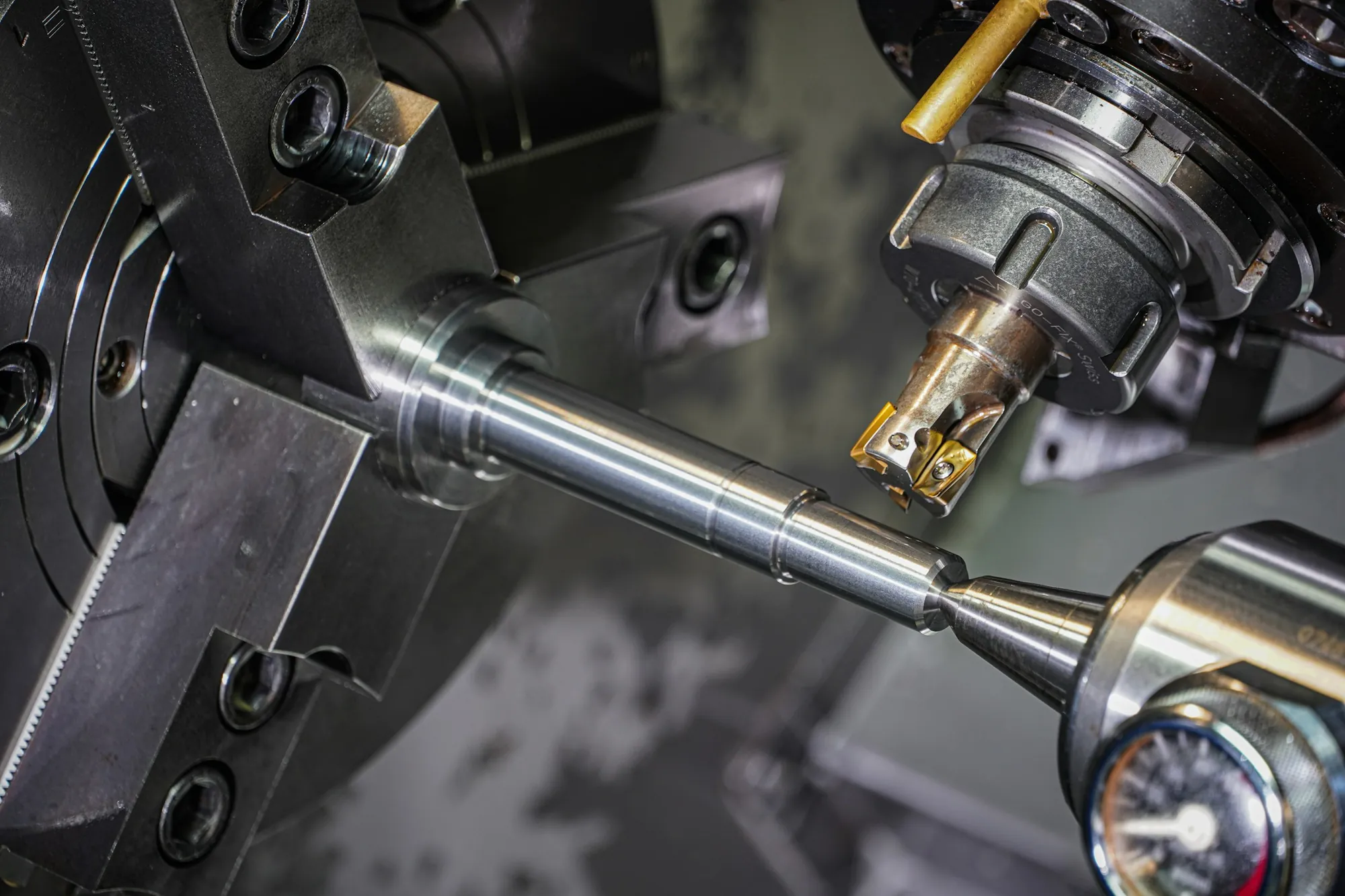 A shaft held in a three-jaw chuck on a lathe, ready for cutting.