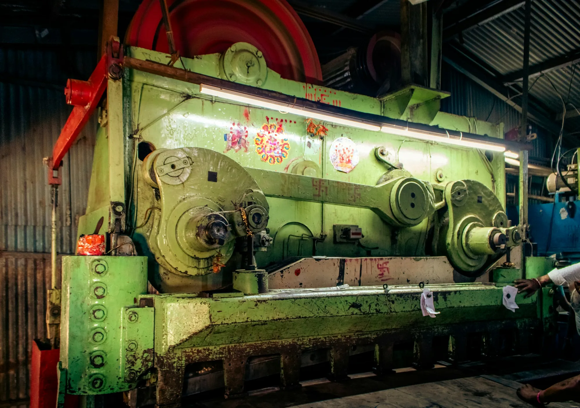 A heavy industrial press standing on a fabrication shop floor.