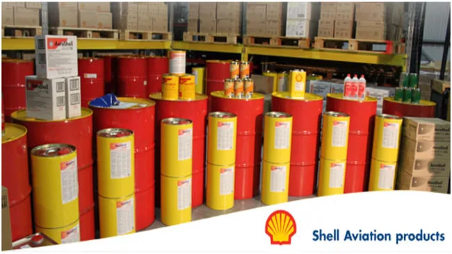 Shell Aviation lubricant drums and pails stacked on warehouse racking, part of the supply side of the defence work.